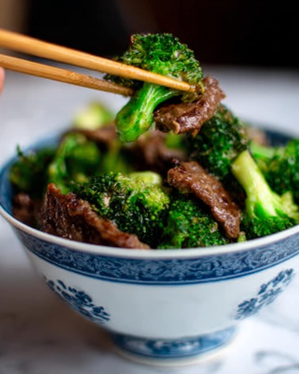 The image shows a white bowl with blue patterns around the top edge, filled with bright green broccoli and dark brown pieces of cooked meat. The broccoli looks fresh and tender, while the meat appears juicy and slightly shiny. A pair of wooden chopsticks held by a woman's hand is lifting a piece of meat above the bowl. The white marbled surface is softly blurred in the background, making the bowl and food stand out clearly. photo taken with an iphone --ar 4:5 --v 7