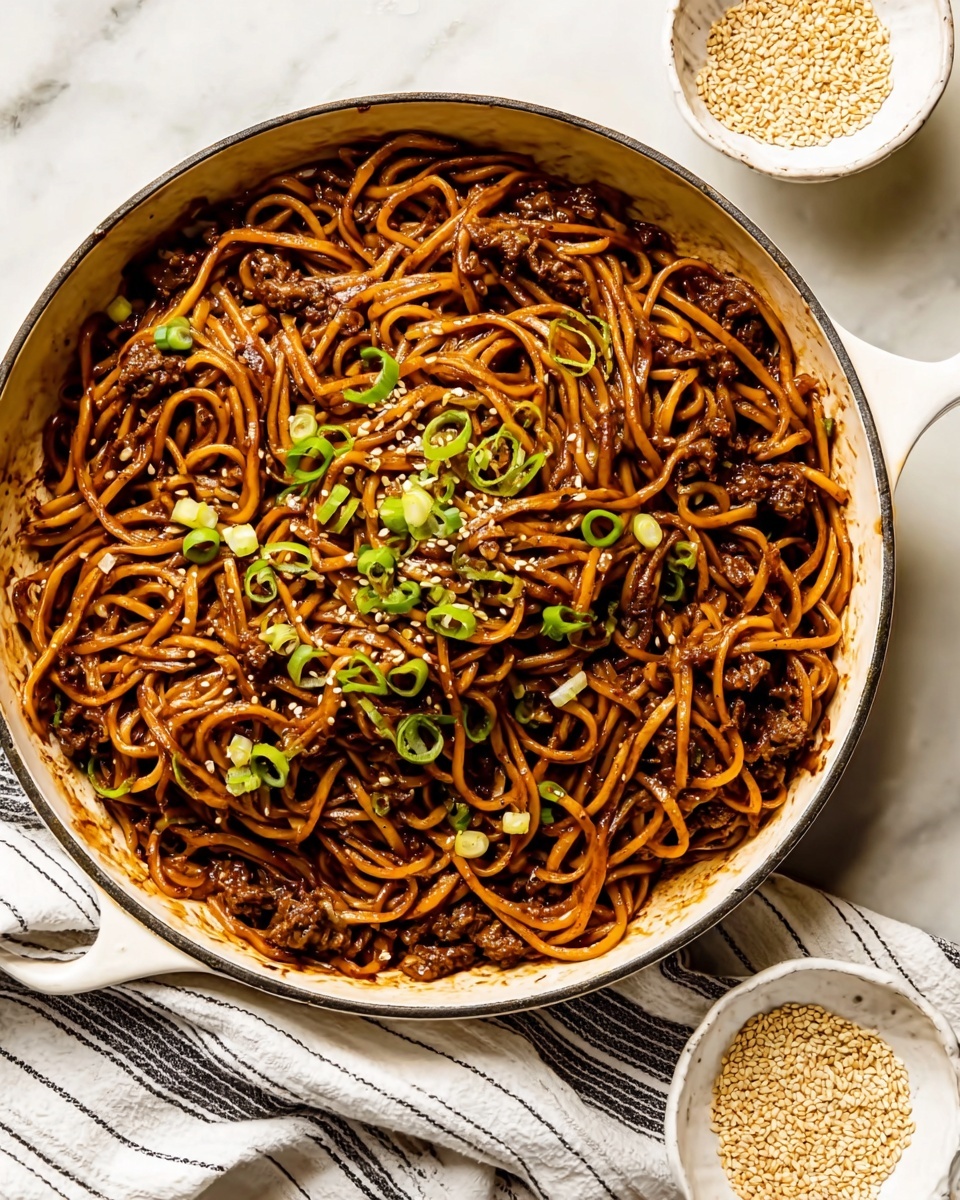 A white pan filled with dark brown noodles tossed in a glossy sauce, topped with small pieces of cooked meat and finely chopped green onions scattered evenly on top. The noodles are twisted and layered naturally, with small bits of white and green mixed throughout, giving a textured look. Next to the pan is a small white bowl with beige sesame seeds. The scene is set on a white marbled surface with a striped cloth partially visible under the pan. photo taken with an iphone --ar 4:5 --v 7