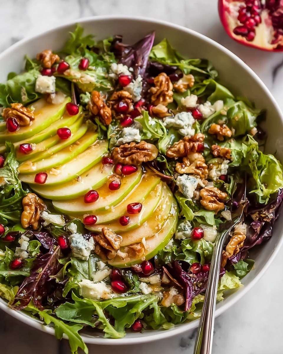 A white bowl filled with a fresh green spinach base, layered with large slices of pale yellow cheese that have a smooth texture. Over the cheese, there are glossy bright red pomegranate seeds scattered evenly, adding a pop of color. Toasted pecans with a rich brown hue are placed throughout, giving a crunchy texture. Small bits of white feta cheese are sprinkled on top. The bowl sits on a white marbled surface with a soft red cloth nearby and some red seeds slightly blurred in the background. Photo taken with an iphone --ar 4:5 --v 7