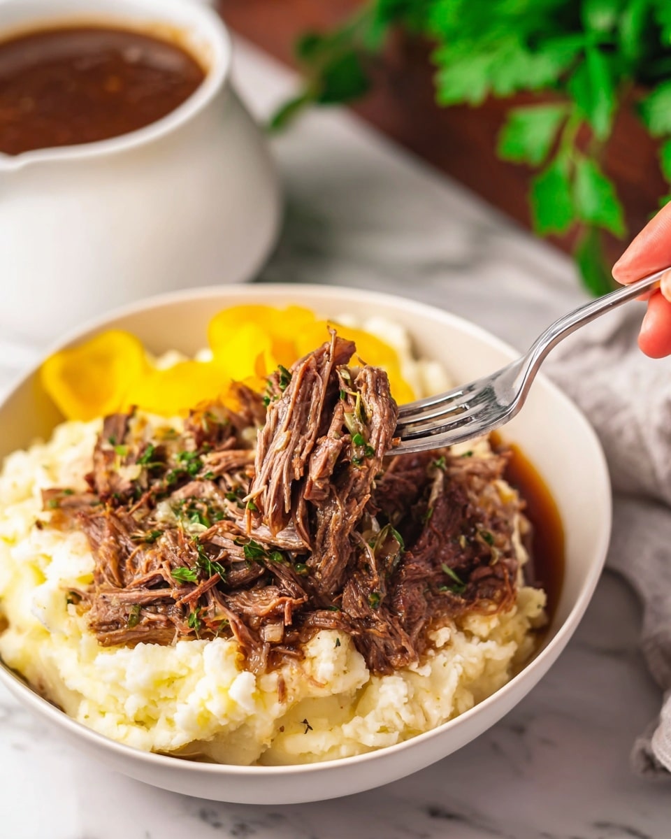 Inside a black slow cooker, there is one large dark brown cooked meat piece on the right side with visible garlic bits on top, surrounded by many smaller shredded chunks of tender brown meat. Scattered throughout are bright yellow whole pepperoncini peppers with stems, sitting on top of slices of translucent cooked onions and sprinkled with small green herb pieces. The meat and peppers are covered in a shiny, thin brown sauce. The photo is taken on a white marbled surface. Photo taken with an iphone --ar 4:5 --v 7