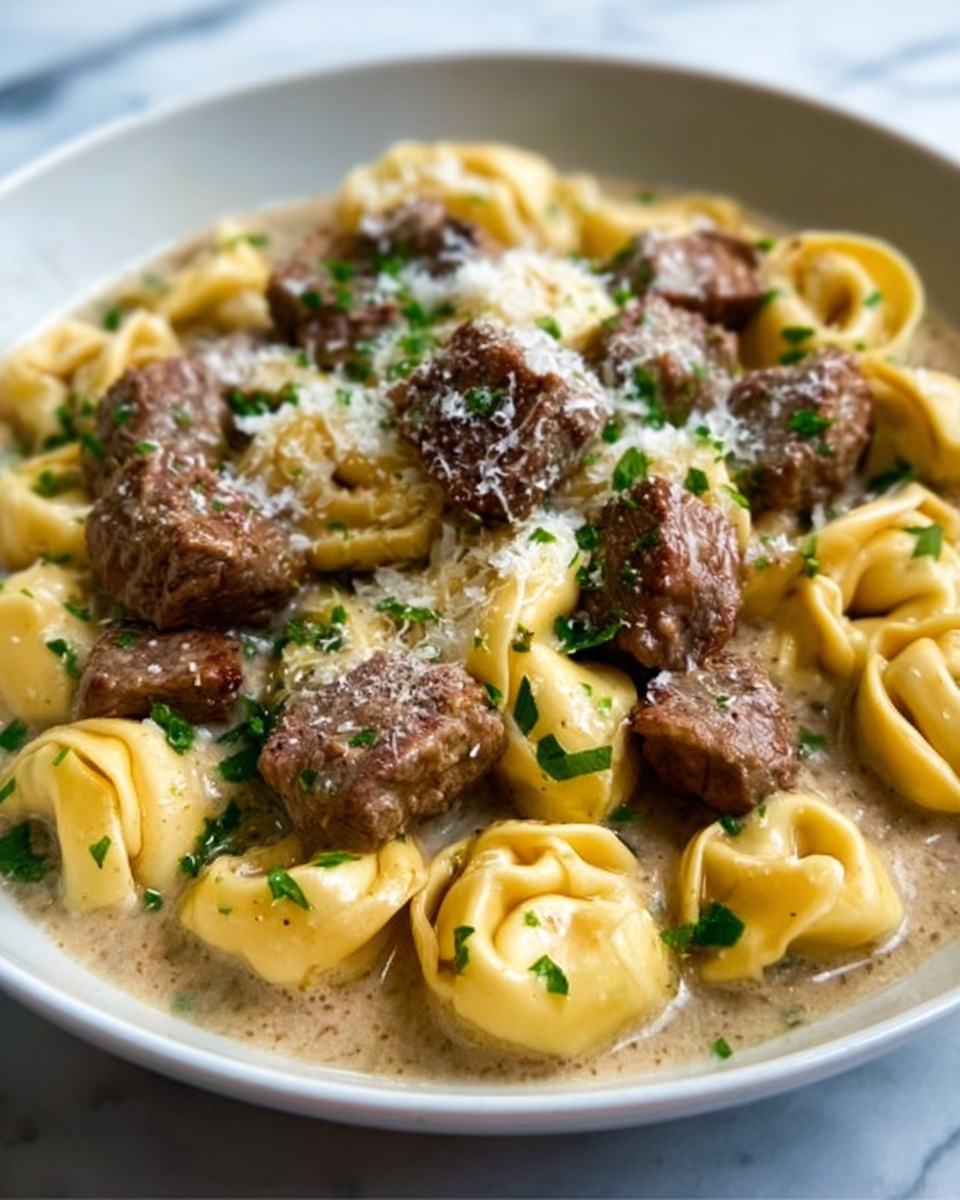 The image shows pasta with meatballs in a creamy sauce. There are multiple meatballs with a browned texture on top, mixed with folded pasta pieces that are yellowish in color. The sauce around the meatballs and pasta is thick and creamy with visible herbs sprinkled on top. The dish sits on a white plate placed on a white marbled surface. Photo taken with an iphone --ar 4:5 --v 7