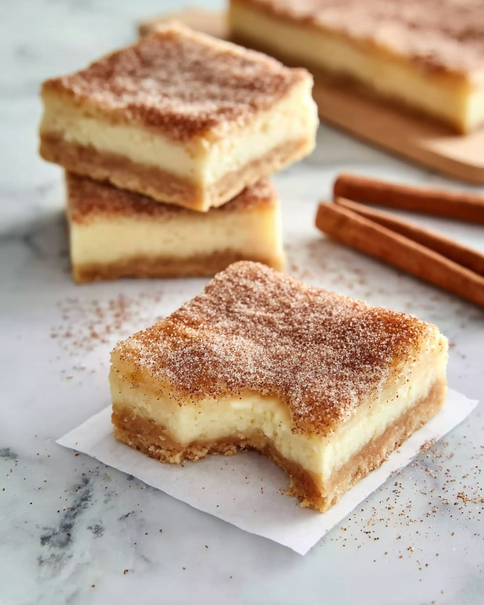 A square dessert bar with three visible layers is shown on a white marbled surface. The bottom layer is a light golden-brown crust, the middle layer is a thick, creamy pale yellow filling, and the top layer is a dusting of light brown cinnamon sugar, giving it a slightly rough texture. In front, one bar rests on a small square of white parchment paper, with a bite taken out of one corner, revealing the creamy filling inside. Behind it, two more bars are stacked slightly apart, all with smooth, clean edges. To the right side, two brown cinnamon sticks lay on the white marbled surface. Photo taken with an iphone --ar 4:5 --v 7