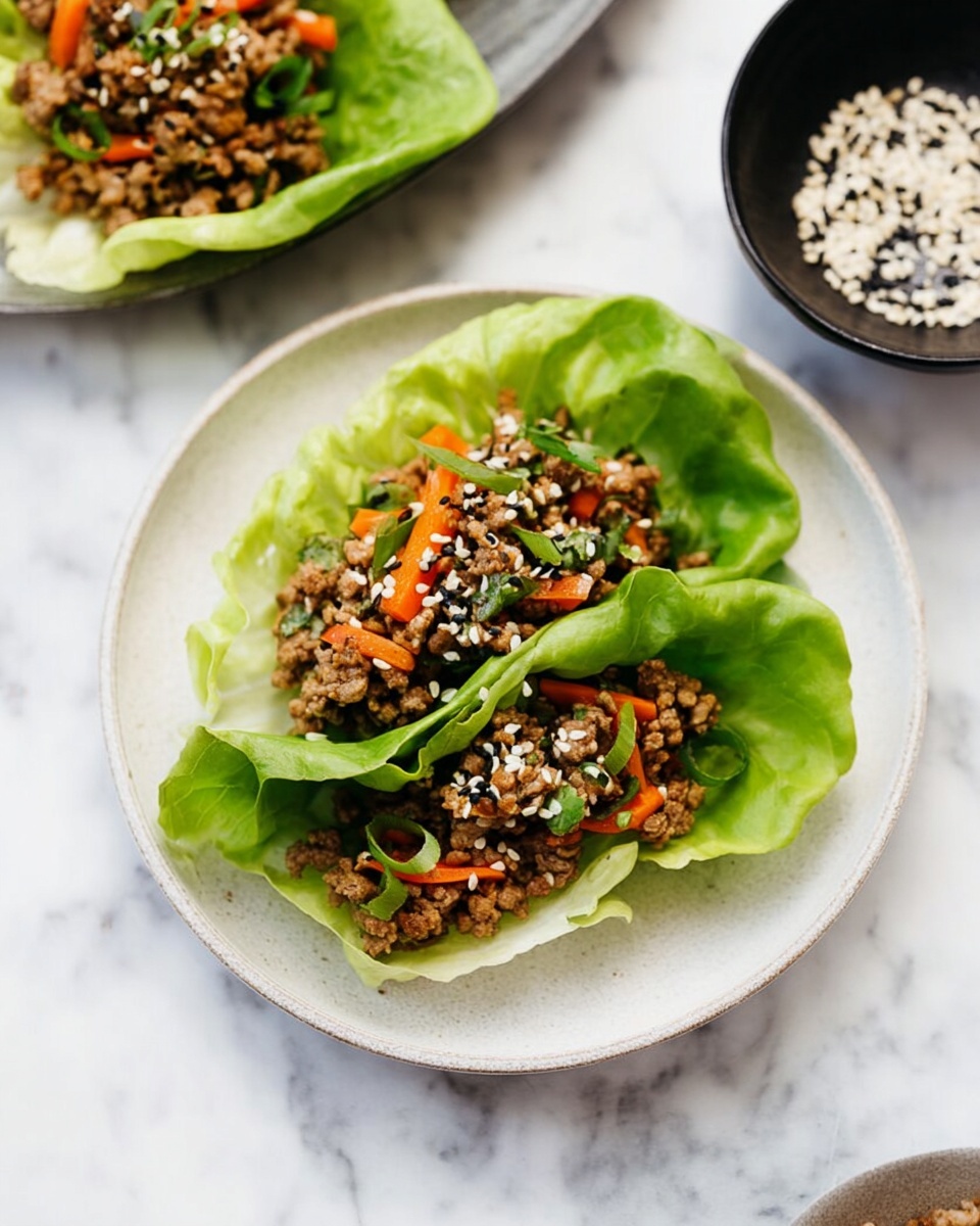 The image shows two lettuce wraps on a white plate resting on a white marbled surface. Each wrap has three layers: a bright green, soft, and slightly crinkled lettuce leaf base, a middle layer of cooked ground meat mixed with small pieces of orange and red bell peppers and green herbs, and a top layer sprinkled with white sesame seeds and black sesame seeds for contrast. The lettuce leaves curve gently around the filling, creating a natural cup shape. To the upper left side, another plate with similar lettuce wraps is partly visible, and to the upper right, a small black bowl holds more white and black sesame seeds. Photo taken with an iphone --ar 4:5 --v 7