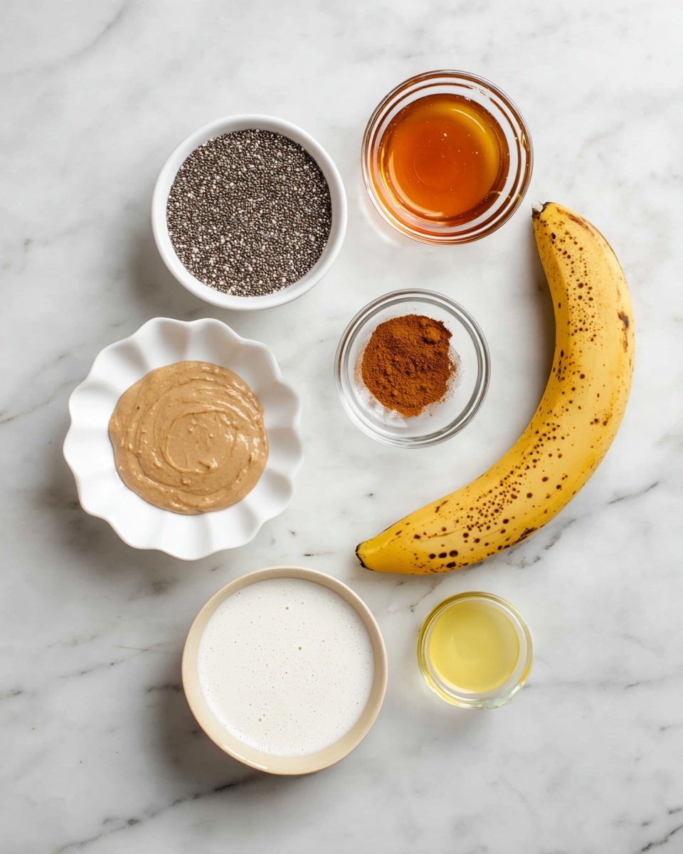 The image shows seven ingredients arranged on a white marbled surface. At the top left is a white bowl filled with small black chia seeds, next to it on the right is a small round glass bowl with amber-colored maple syrup. Below the chia seeds is a white scalloped bowl holding light brown nut butter with a smooth texture, and beside it is a small clear glass bowl containing a pile of brown cinnamon powder. To the right of the cinnamon is a small white bowl filled with golden liquid, likely oil. Below all these, a white bowl with a beige rim contains white coconut milk with a few bubbles on the surface. On the far right, a ripe yellow banana with brown spots leans against the bowl. Photo taken with an iphone --ar 4:5 --v 7