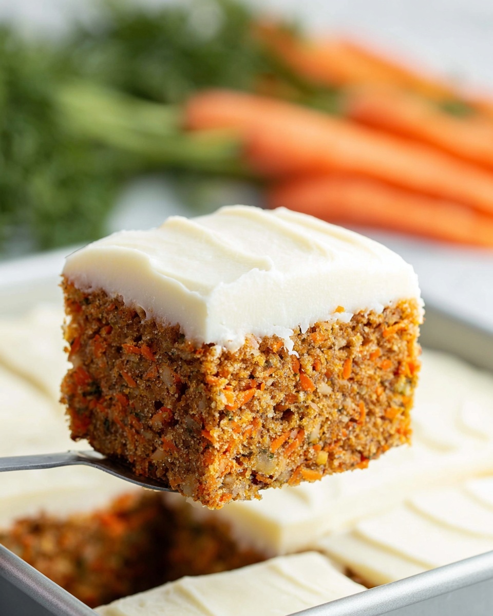 A close-up view of a single slice of carrot cake lifted above a white baking pan, showing two layers: a dense, textured carrot cake base with small bits of orange carrot visible throughout, and a smooth, creamy white frosting layer on top. The cake is square-shaped with clean, straight edges. The background features blurred green herbs and orange carrots on a white marbled surface. Photo taken with an iphone --ar 4:5 --v 7