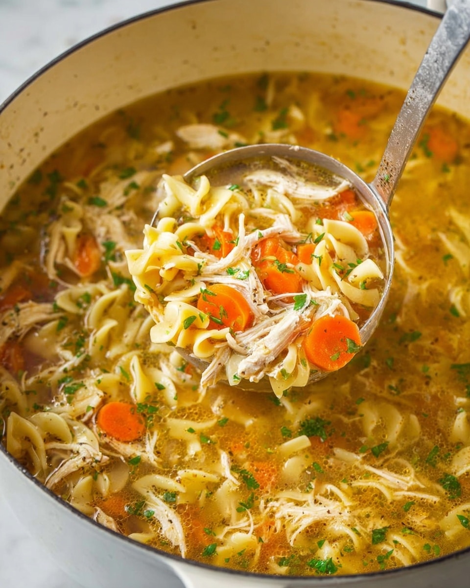 The image shows a close-up of a large white pot filled with chicken noodle soup. The soup has layers of curly egg noodles, light orange carrot slices, shredded white chicken, and green parsley pieces floating in a clear, golden broth. A metal ladle lifts a scoop from the pot, holding a mix of noodles, carrot slices, and chicken strands, with broth dripping slightly. The pot sits on a white marbled surface, giving a clean and bright look to the scene. photo taken with an iphone --ar 4:5 --v 7