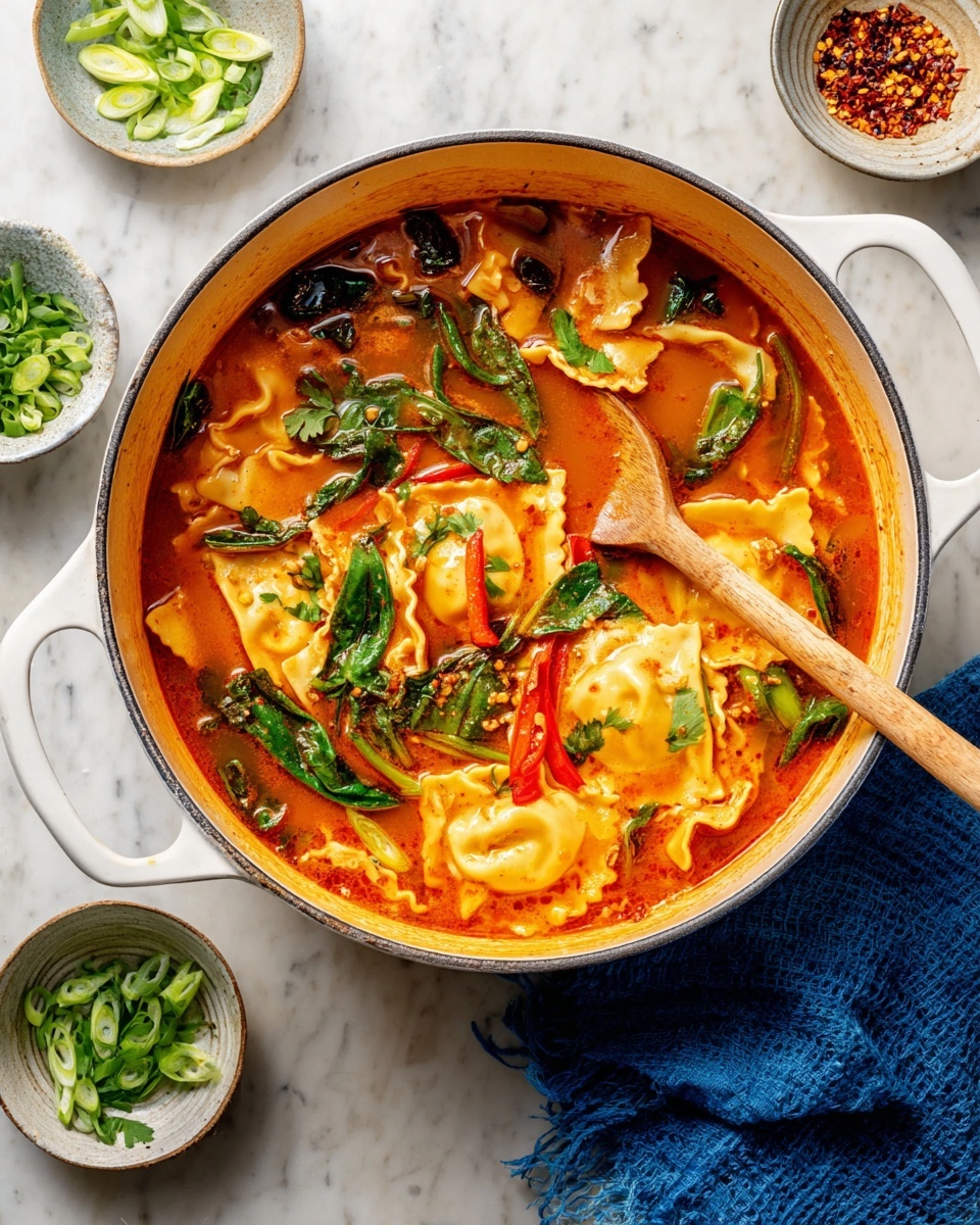 A large white pot filled with a bright orange-red soup that has folded ravioli pasta floating in it. The soup includes green leafy vegetables, red bell pepper strips, and some chopped herbs sprinkled on top. A wooden spoon rests inside the pot, partially submerged in the soup. Around the pot, there are small white bowls containing sliced green onions, chili flakes in oil, and chopped parsley. A folded blue cloth is placed to the side on a white marbled surface. photo taken with an iphone --ar 4:5 --v 7