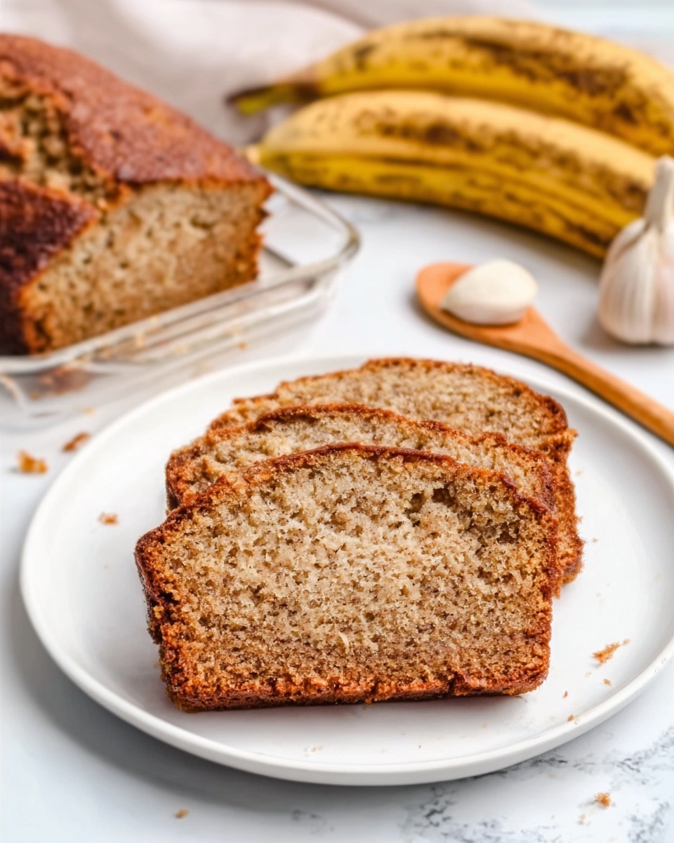 The image shows a single slice of moist banana bread placed in the center of a white plate. The bread has a soft texture with small air pockets and a slightly rough top crust that is darker brown. The slice is positioned horizontally, showing its dense, crumbly inside layers with a light brown color mixed with darker brown bits. In the background, there is a whole banana with brown spots and a small bunch of garlic cloves on a white marble surface. A white glass dish holding more banana bread sits slightly out of focus behind the plate. A woman's hand holds a wooden spoon nearby. The photo taken with an iphone --ar 4:5 --v 7