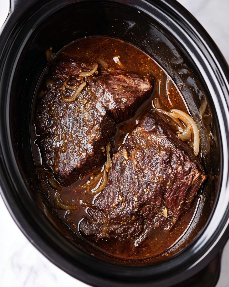The image shows two large pieces of dark brown cooked meat with a seared, slightly crispy texture on the edges, sitting in a pool of rich, glossy brown sauce mixed with thinly sliced cooked onions. The meat and sauce are inside a black oval slow cooker with a shiny surface, placed on a white marbled background. The glossy sauce has a few small visible bits of seasoning, and the onions look soft and translucent, resting mostly on top and around the meat. The slow cooker is open and filled mostly with the meat and sauce, taking up most of the space inside. Photo taken with an iphone --ar 4:5 --v 7