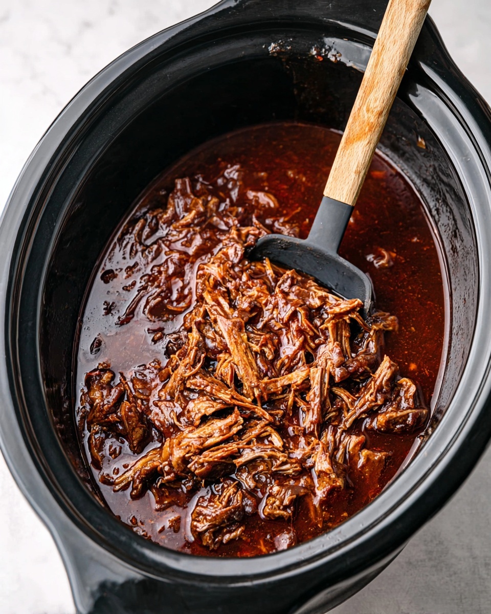 A black slow cooker filled with rich, dark brown shredded meat in thick, glossy sauce; the meat appears tender and fibrous, spread evenly throughout the sauce with a mix of darker and lighter brown shades showing different textures; a black serving spoon with a light wooden handle rests on the right side inside the cooker, partially submerged in the sauce. The background is a white marbled surface photo taken with an iphone --ar 4:5 --v 7