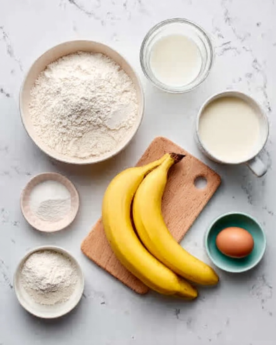 The image shows a white bowl filled with white flour on the left side of a white marbled table. Next to it, there is a small white bowl containing a white powder, and another small white bowl with a white granular substance. A clear glass bowl with a white liquid sits nearby, and a white mug with milk is placed to the far right. In the center, two yellow bananas rest on a small wooden board. At the bottom right corner, there is a brown egg in a small teal bowl. The overall setting is bright and clean, with all items neatly arranged on the white marbled surface. A woman's hand is not visible in the image. photo taken with an iphone --ar 4:5 --v 7