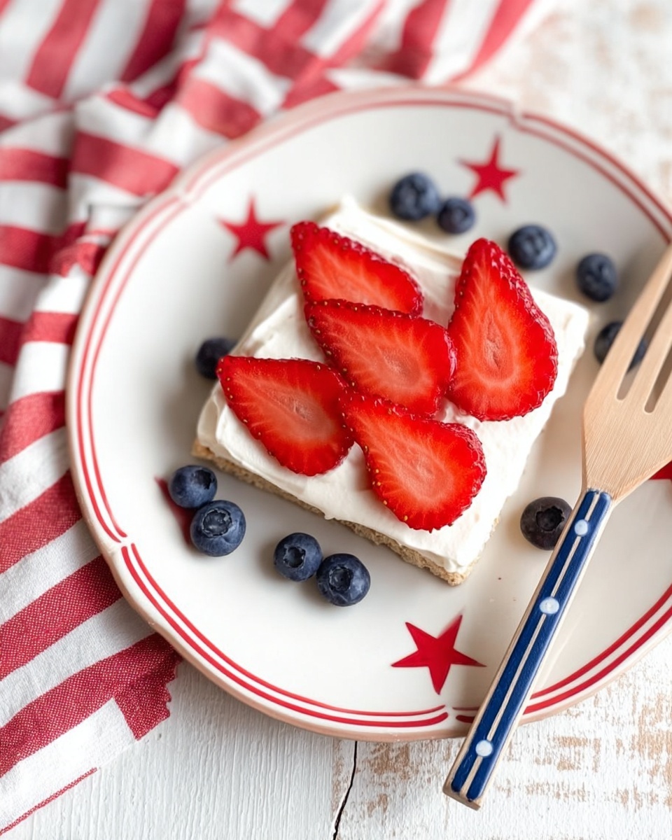 A white plate with red lines around the edge and a red star at the bottom holds a square piece of flatbread or biscuit topped with a thick, smooth layer of white cream. On top of the cream, there are six evenly spaced red strawberry slices with visible seeds and a juicy texture. Around one side of the bread on the plate, there are scattered round dark blue blueberries with a slight shine. To the right of the plate, a wooden fork with blue painted stripes lies on a folded red and white striped cloth. The background is a white marbled surface with visible light gray veins. Photo taken with an iphone --ar 4:5 --v 7