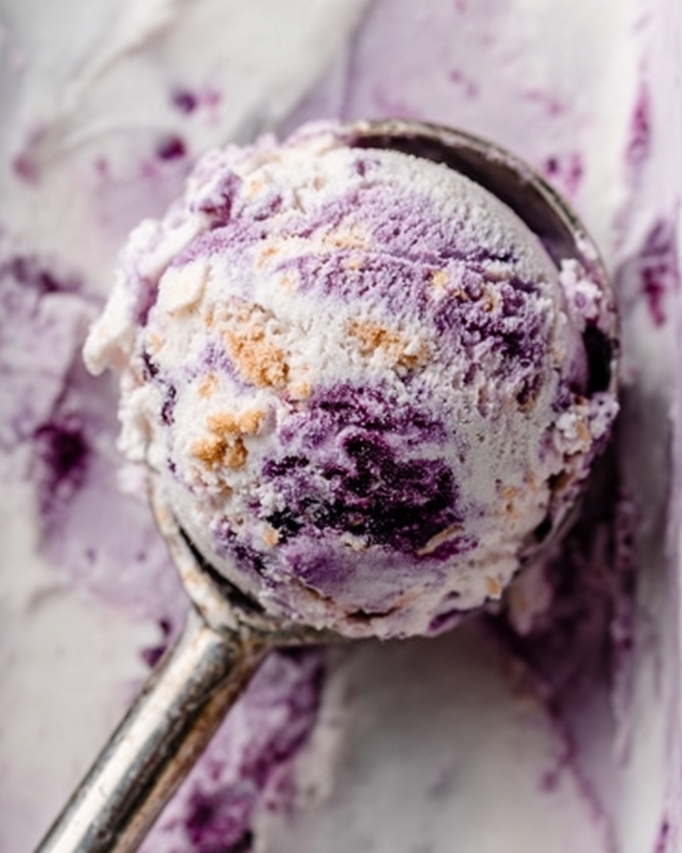The image shows a close-up of a single scoop of purple and white ice cream held in an ice cream scoop over a white marbled surface. The ice cream has a creamy texture with swirls of deeper purple and hints of dark spots scattered through it. The scoop is metallic, shiny, and reflects some light. The background is a soft, blurred mix of white marbled texture and hints of purple ice cream spread softly across it. photo taken with an iphone --ar 4:5 --v 7