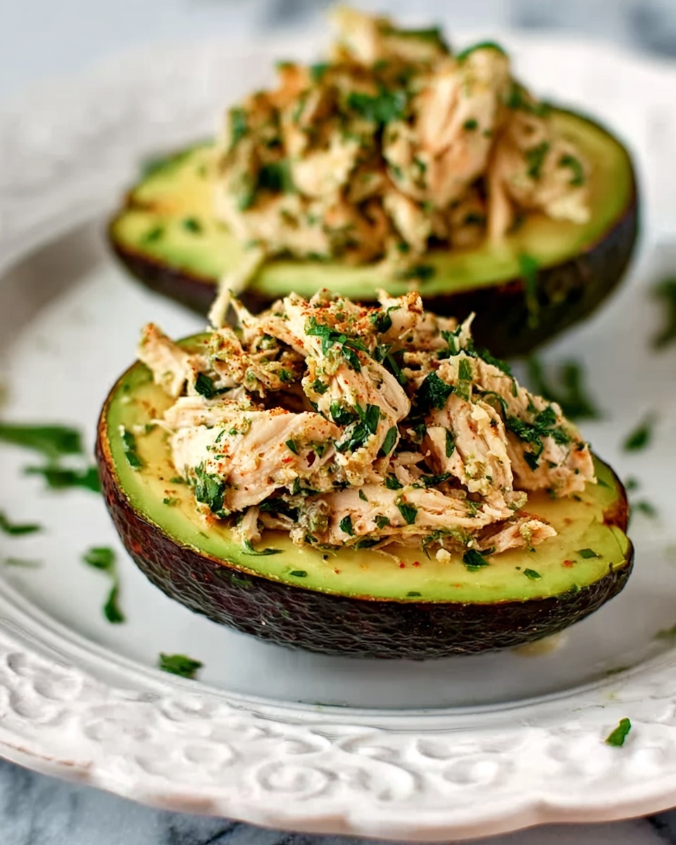 The image shows three avocado halves filled with a creamy mixture of shredded chicken, small green peas, red bits that look like tomatoes, and topped with fresh green herbs. The avocados have dark green, bumpy skin with smooth, light green flesh inside. The filled avocados are placed on a wooden surface with some fresh herbs scattered around. The creamy mixture is layered inside the hollow where the avocado seed would be, overflowing slightly to show texture. photo taken with an iphone --ar 4:5 --v 7