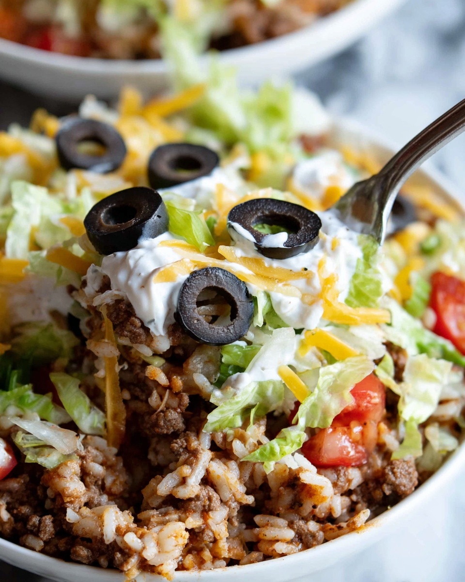 This close-up image shows a layered dish with a base of cooked ground meat mixed with small pieces of red pepper and rice, topped with shredded pale green lettuce. Over the lettuce, there is a layer of creamy white sauce with melted yellow and white shredded cheese sprinkled on top. Several sliced black olives are scattered over the cheese, adding a dark round contrast. A woman's hand with a fork is scooping a portion from a white bowl, all placed on a white marbled surface. photo taken with an iphone --ar 4:5 --v 7