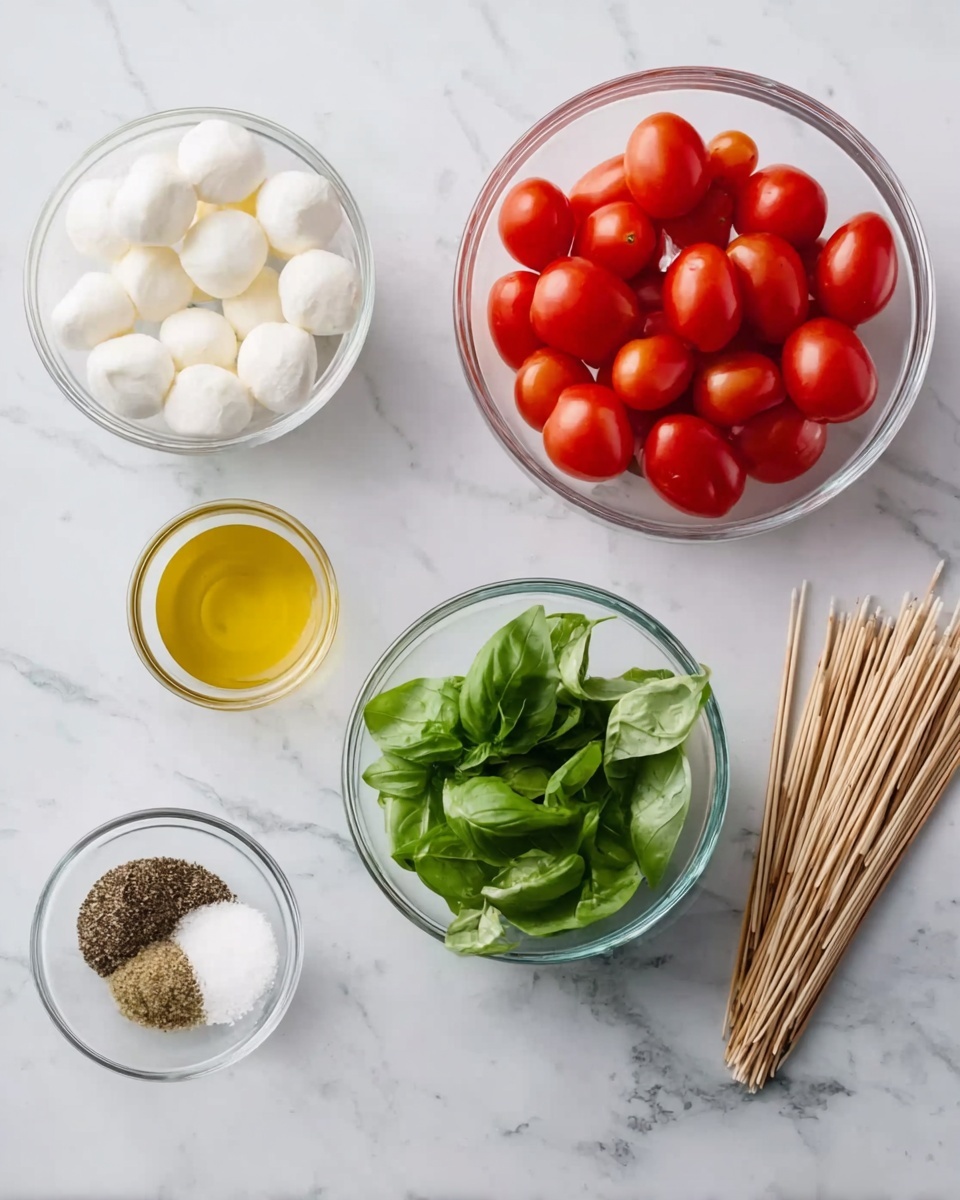 The image shows a white marbled surface with six clear glass bowls arranged neatly. The largest bowl on the right holds bright red grape tomatoes. To the left of this, a medium bowl contains small round white mozzarella balls. Below these, a smaller bowl is filled with fresh green basil leaves with visible veins. Above this, a small bowl holds olive oil with a smooth shiny yellow surface. To the left, another tiny bowl contains coarse black pepper and salt mixed together. At the top right corner, there are wooden skewers bundled together with a natural wood texture. photo taken with an iphone --ar 4:5 --v 7