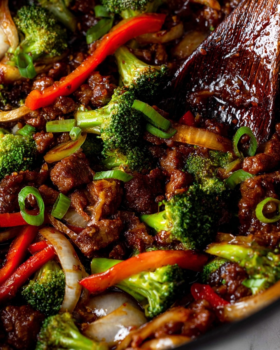 A close-up view of a stir-fry dish with three main layers: the bottom layer shows small, dark brown cooked meat pieces mixed with a thick shiny sauce, the middle layer has bright green broccoli florets and light green chopped spring onions scattered on top, and the top layer features thinly cooked translucent onion slices and bright red bell pepper strips. On the right side, a dark wooden spoon coated with sauce is partially visible. The dish is placed on a white marbled surface. photo taken with an iphone --ar 4:5 --v 7