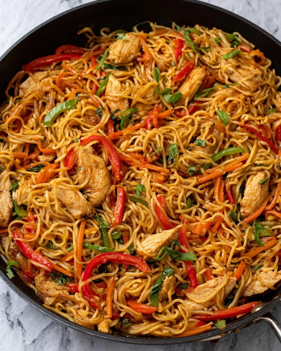 This is a close-up view of a black pan filled with cooked noodles mixed with sliced cooked chicken pieces, red and green bell peppers, and small green herbs. The noodles are light brown and slightly shiny from sauce, and the chicken pieces are soft light brown. The vegetables add bright red and green colors, scattered evenly throughout the noodles. The pan rests on a surface with a white marbled texture. Photo taken with an iphone --ar 4:5 --v 7