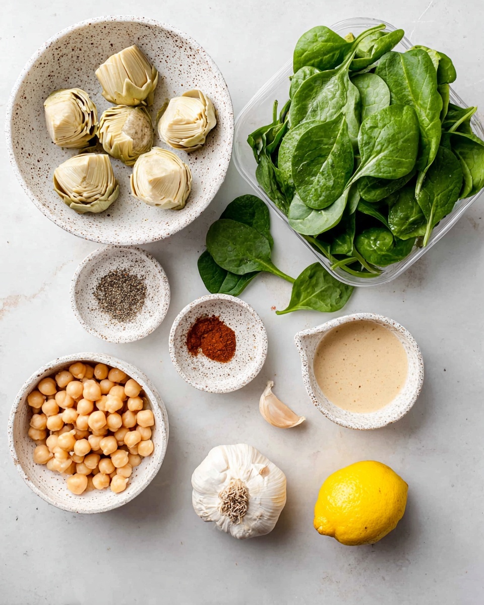 The image shows several ingredients laid out on a white marbled surface. There is a white speckled bowl with six light beige artichoke hearts on the upper left. To the right of this, there is a clear plastic container filled with fresh green spinach leaves, some spilling onto the surface. Below the artichokes, two small white textured bowls hold different spices; one has black pepper and salt, and the other has brown and red powdered spices. On the lower left, a white bowl contains pale yellow chickpeas, slightly shiny and plump. Near this, a small bowl with a spout contains a light beige sauce or paste. To the bottom right, there is a whole bright yellow lemon sitting on the surface, near a single clove of white garlic. photo taken with an iphone --ar 4:5 --v 7