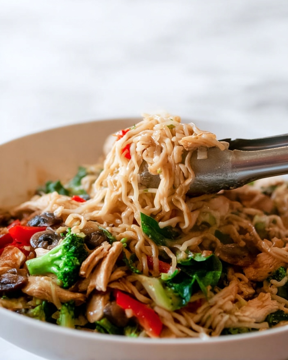 The image shows a close-up of a white bowl filled with three main layers: the bottom layer is light brown noodles, soft and tangled; the middle layer has bright green broccoli florets and thin, red bell pepper slices adding pops of color; the top layer consists of light tan pieces of cooked chicken mixed with a few dark brown mushrooms and scattered vegetable pieces. A metal tong held by a woman's hand is lifting some noodles and chicken from the bowl. The background is a smooth white marbled texture. photo taken with an iphone --ar 4:5 --v 7