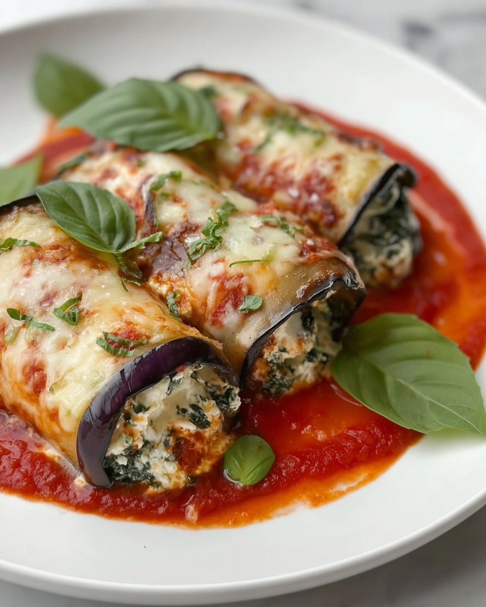 The dish shows three rolled eggplant slices on a white plate, each stuffed with a creamy white cheese mixed with green spinach. The eggplant skin is a deep purple, contrasting with the white and green filling inside. The rolls are covered with a layer of melted golden cheese, with slight browning and small green herb pieces sprinkled on top. Around the rolls, there is a bright red tomato sauce spread on the plate, adding a rich color contrast. Fresh green basil leaves are placed on and around the rolls for garnish. The plate sits on a white marbled surface. Photo taken with an iphone --ar 4:5 --v 7