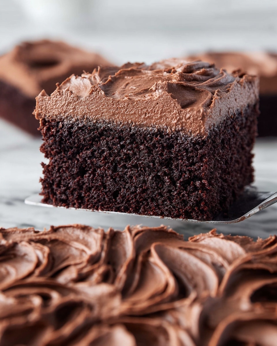 A close-up side view of a single thick slice of chocolate cake with one dark brown moist layer and a thick, rough-textured lighter brown chocolate frosting layer on top, held above a white marbled surface with the rest of the cake showing the same frosting spread in smooth, swirled patterns. Photo taken with an iphone --ar 4:5 --v 7