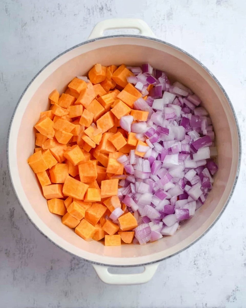 The image shows a white round pot on a white marbled surface. Inside the pot, there are two clear layers of chopped vegetables side by side: bright orange sweet potatoes on the left and light purple diced onions on the right. The vegetables have a fresh and raw texture with sharp edges from the chopping. The bright colors contrast well with the white pot and marbled background. photo taken with an iphone --ar 4:5 --v 7