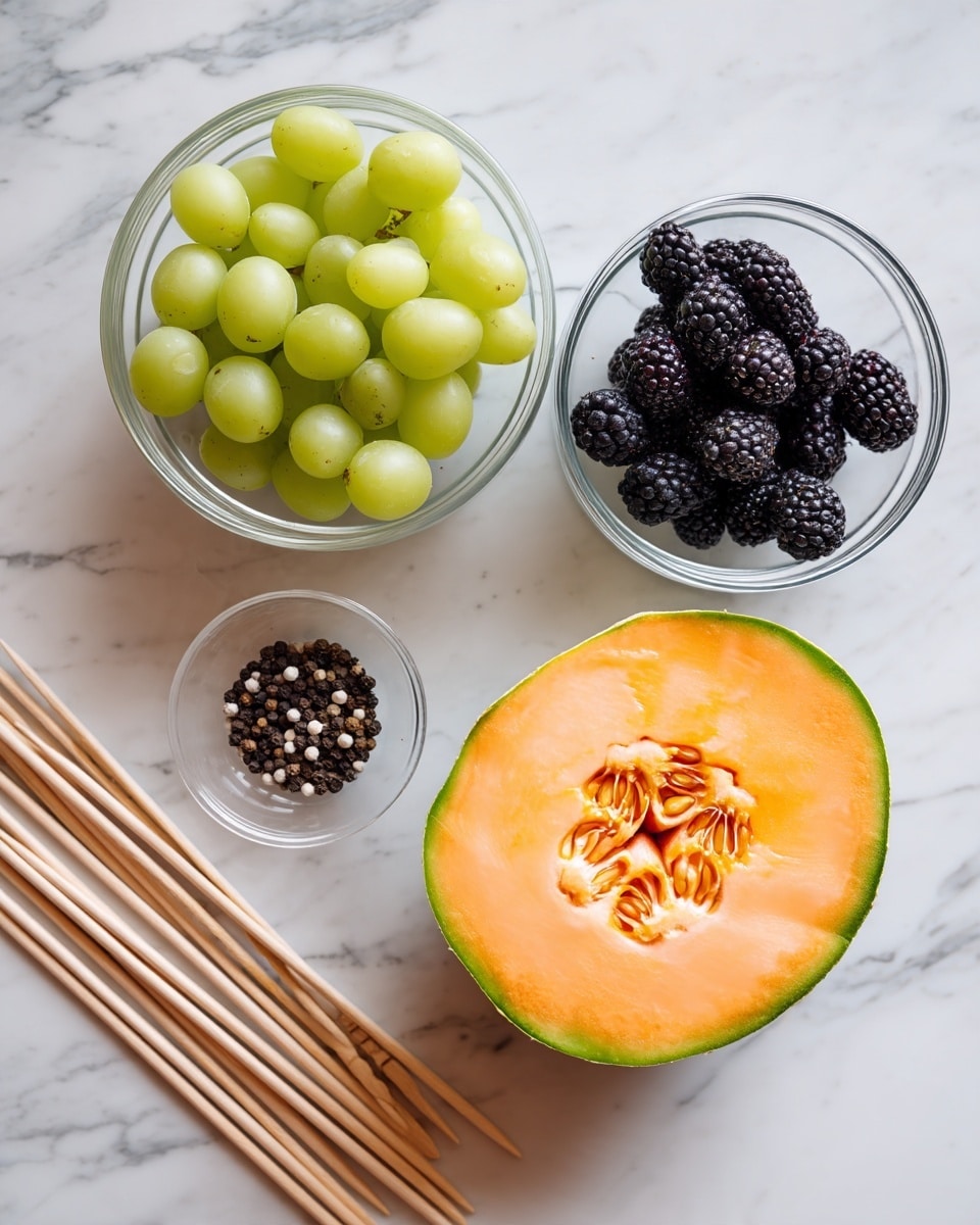 Spooky Fruit Kabobs Recipe 4 The image shows a neat arrangement of fresh fruits and ingredients on a white marbled surface. In the center, there is a half of a cantaloupe melon, showing its orange flesh with seeds in the middle. To the left is a clear glass bowl filled with green grapes. To the right, another clear glass bowl holds blackberries. Above the cantaloupe is a small clear bowl containing black and white peppercorns. On the far left, there are several wooden skewers laid out straight. The colors are soft and natural, and all items are cleanly placed with no overlaps. Photo taken with an iphone --ar 4:5 --v 7