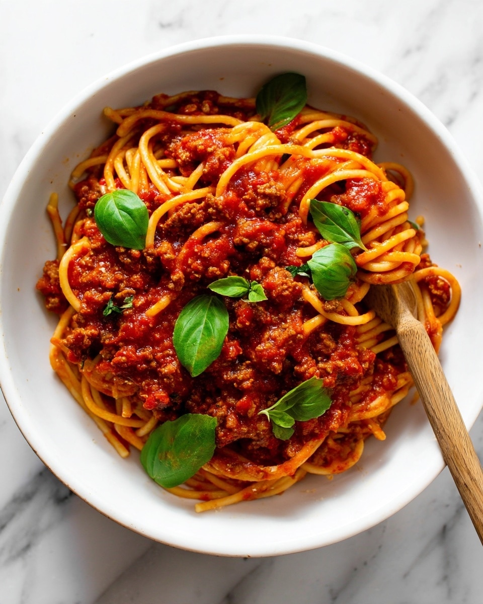 Two white bowls hold servings of spaghetti with sauce. The dish has three main layers visible: the bottom layer is light yellow cooked spaghetti noodles twisted in a pile, the middle layer is a chunky red tomato sauce mixed with browned ground meat pieces, and the top layer is sprinkled white grated cheese dusted over the sauce. The bowls are placed on a white marbled surface with a white cloth partially seen in the background. The front bowl is focused, showing details of the noodles and meat sauce clearly, while the second bowl is blurred in the background. photo taken with an iphone --ar 4:5 --v 7