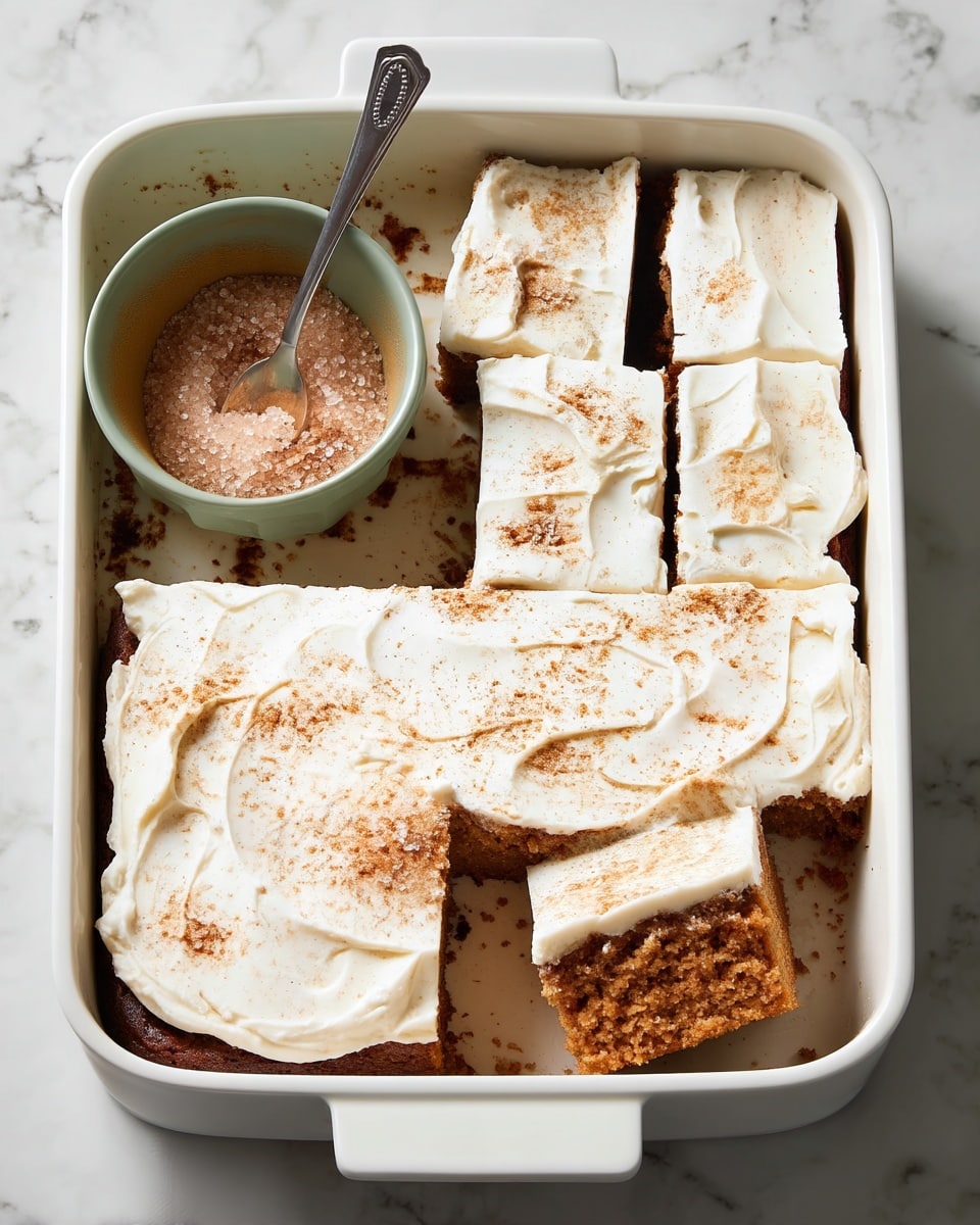 A close-up image of a single square piece of carrot cake being lifted from a white rectangular baking dish on a white marbled surface. The cake has two layers: a dense, moist brown bottom layer with small bits of carrot and nuts visible throughout, and a thick, smooth off-white top layer of cream cheese frosting with a lightly textured surface and a sprinkle of cinnamon on top. The piece is held by a metal spatula with a wooden handle, angled toward the camera to show the height and texture of the cake. Photo taken with an iphone --ar 4:5 --v 7